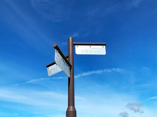 青空を背景に立つ尾根上の指導標。