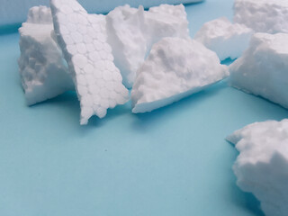white styrofoam shards . industrial waste scattered around on blue cardboard
