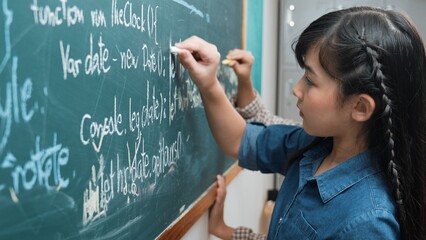 Skilled asian girl writing engineering prompt and programing system while standing blackboard with...