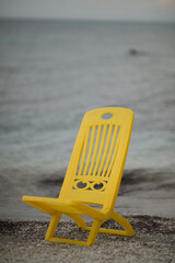 Naklejka premium yellow chair on the beach