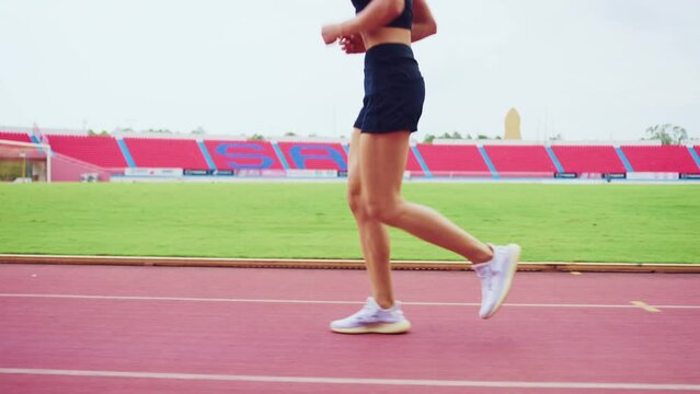 Close up of sportswoman sprint on a running track outdoors on stadium.