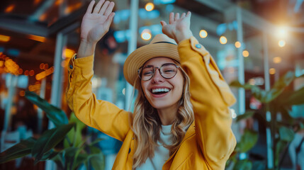 Obraz premium Cheerful young woman in yellow coat with raised hands