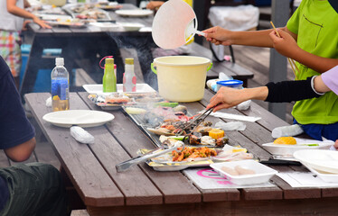 屋外で海鮮ＢＢＱを焼く家族