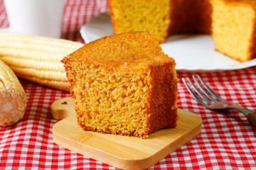slice Homemade corn cake on wooden table. Typical Brazilian party food.