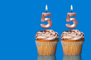 Birthday Cupcakes With Candles Lit Forming The Number 55.