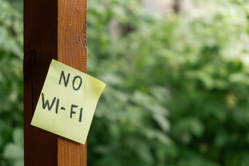 NO WI FI text on paper note on background of greenery garden wooden alcove outdoor. Concept of...