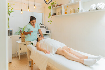 Masseur explaining procedure to a woman lying in a spa