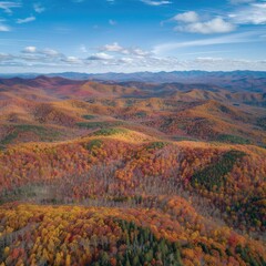 Aerial perspective of a mountain range during autumn, with vibrant foliage