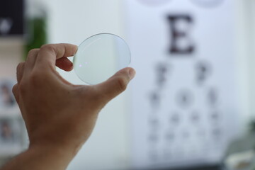 Hand holding glasses lenses 