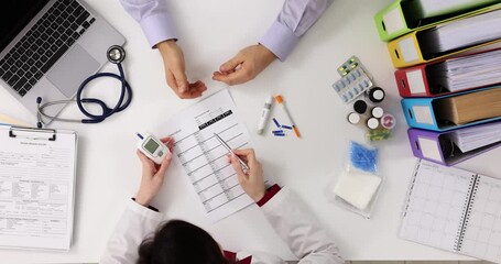 Doctor and patient discuss blood sugar test results top view
