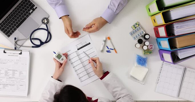 Doctor and patient discuss blood sugar test results top view