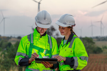 Engineer wearing safety uniform using tablet discussed plan about renewable energy at station...