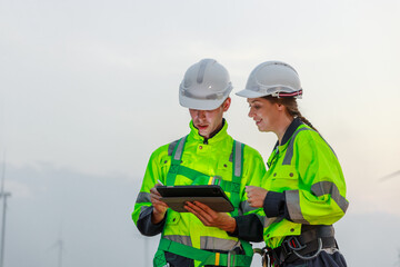 Engineer wearing safety uniform using tablet discussed plan about renewable energy at station...