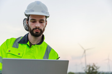 Engineer wearing safety uniform holding laptop discussed plan about renewable energy at station energy power wind. technology protect environment reduce global warming problems.