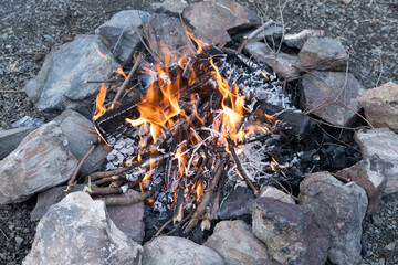 Looking down into active fire in camp fire ring while camping during wet spring conditions.