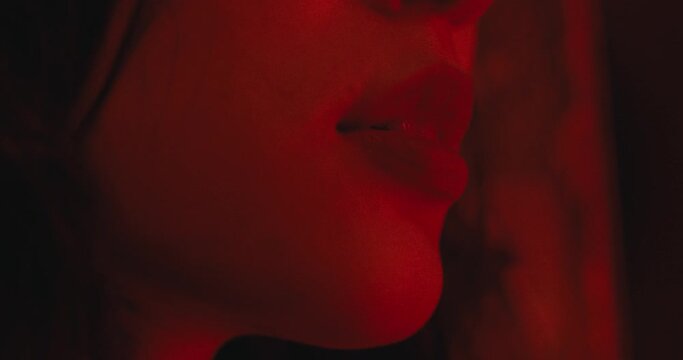 close up on lip with red district and soft red light in background , sexy attractive young asiatic woman portrait