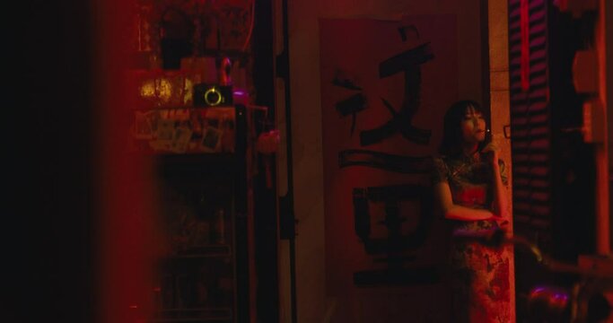 sexy attractive young female model woman standing in front of a door of club bar cafe in south east asia while smocking cigarettes