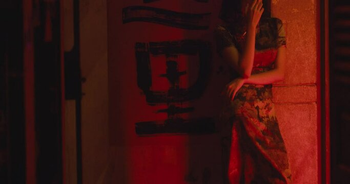 attractive sexy young female woman asiatic smocking a cigarette in red light district of south east asia