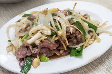 A delicious dish of beef and onions served on a white plate on the table in Tainan, Taiwan