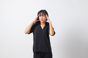 Portrait of overwhelmed Asian woman in casual shirt touching her head, having headache, and feeling...