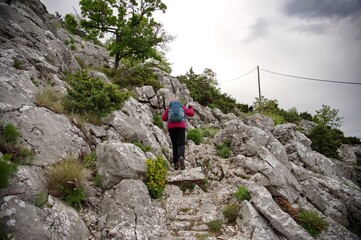 Senior woman hiking in rocky landscape in Croatia