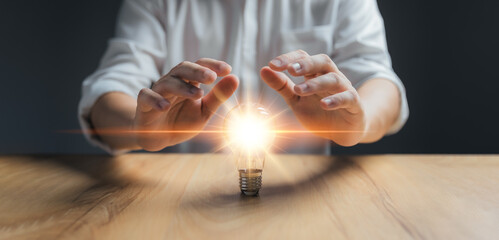 Businessman protect light bulb, Creative new idea. Innovation, brainstorming, inspiration and...