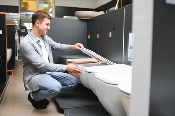 Man choosing home toilet in store