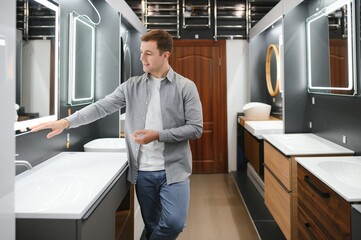 Man choosing new bathroom furniture at the plumbing shop with lots of sanitary goods