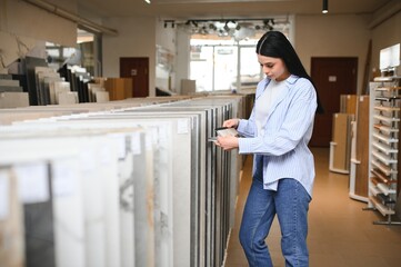 Female customer choosing kitchen ceramic tile in store