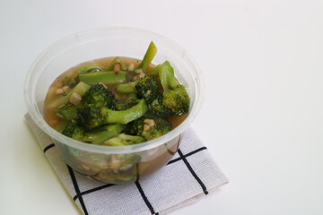 Stir fried broccoli or ca broccoli with thick sauce made from cornstarch. with garlic pieces on it. Indonesian food, served in a bowl.