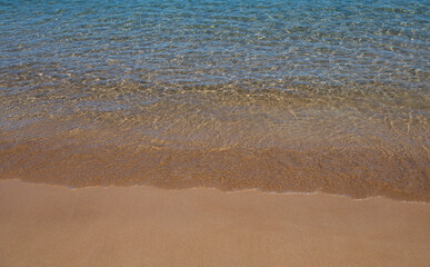 Beach with golden sand, turquoise ocean water. Panoramic sea view. Natural background for summer vacation.