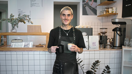 Handsome barista guy work coffee shop. Tattooed hipster man portrait. Happy male face smile. Joy...