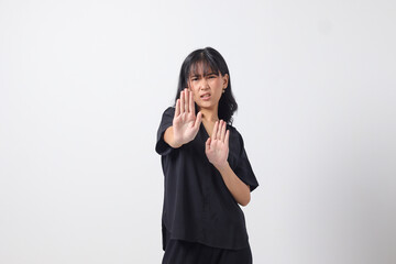 Portrait of attractive Asian woman forming a hand gesture to avoid something. Advertising concept....