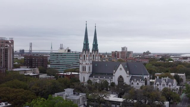 Wide aerial push-in shot of the historic Cathedral Basilica of Saint John the Baptist in Savannah, Georgia. 4K