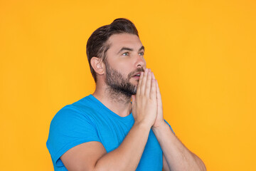Christian Religion. Man praying. Isolated portrait of male pray. Man kneeling and praying close up portrait. Praying hands.