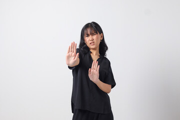 Portrait of attractive Asian woman forming a hand gesture to avoid something. Advertising concept....