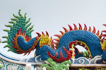 Fototapeta premium Dragon at Chinese Shrine. Chainese gold dragon on blue sky backgrounds