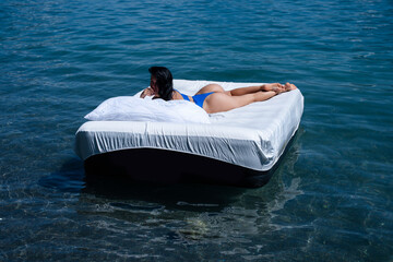 Woman with inflatable mattress in pool, top view. Sexy woman sleeping or resting on a mattress in...