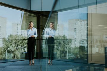 Professional woman standing in modern office building on a sunny day
