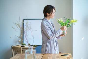 花を飾った花瓶を持つ女性