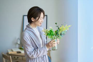 花を飾った花瓶を持つ女性