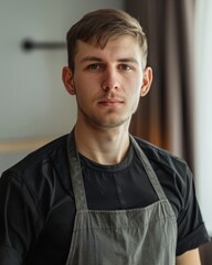 Fototapeta premium portrait of a young man in a black shirt and apron