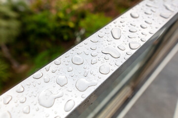 Drops of water from rain on a metal railing