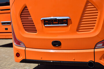 Modern orange buses. The back of the bus.