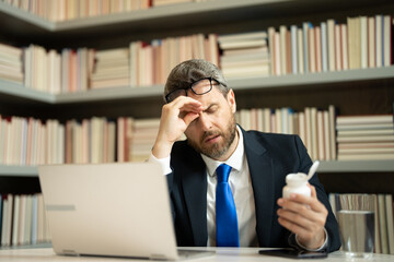 Tired man having a terrible headache. Exhausted man feeling unhealthy, upset about headache illness. Stressed middle-aged man having headache. Migraine and headache concept.