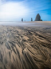 Beautiful patterns and textures on sand beach and sea stack in the ocean. Cannon Beach. Wahington...