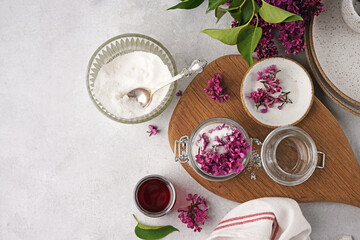 Preparation of syrup from the flowers of lilac. White table and wooden board . Copy space, top view