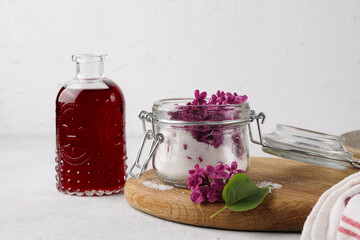 Preparation of syrup from the flowers of lilac. Glass jar, wooden board. White background. Copy space