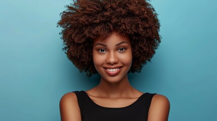  A smiling person in a black shirt and curly afro against a blue background