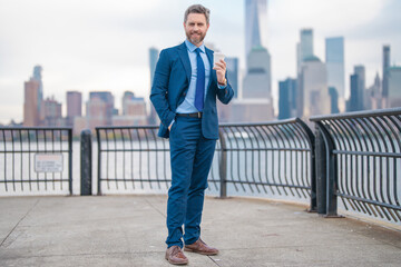 Mature Business man with dollars money. Excited manager with dollar money on street. Rich business man in suit hold dollar cash. Businessman hold 100 dollars banknotes at city. Dollars banknote.